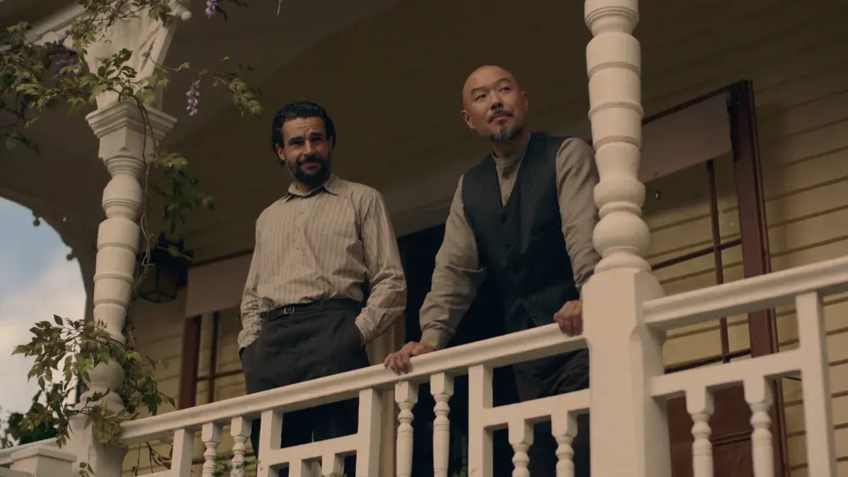 Christopher Abbott en Adam Trask et Hoon Lee en Lee, accoudés à la balustrade d'un porche, dans la série À l'est d'Éden