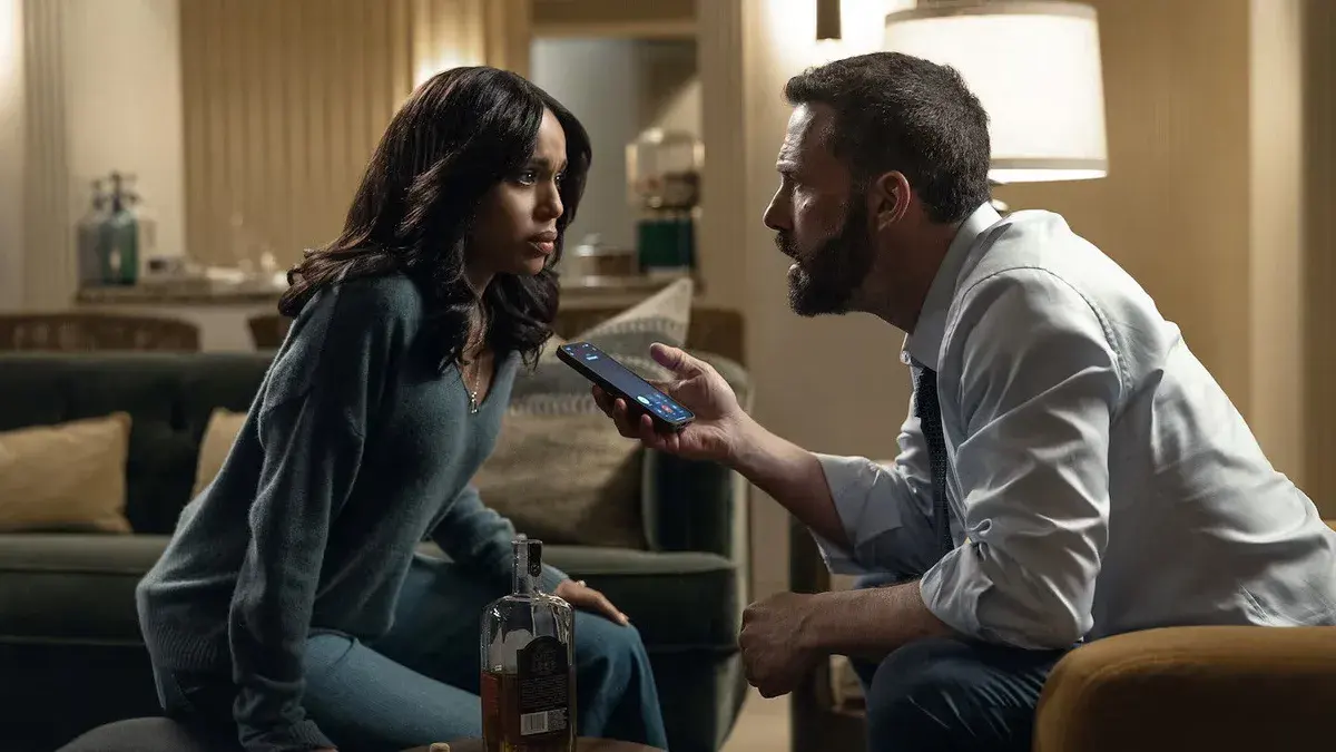 Kerry Washington et Ben Affleck face à face dans un salon, lui tenant un téléphone en plein appel, dans le film Animals