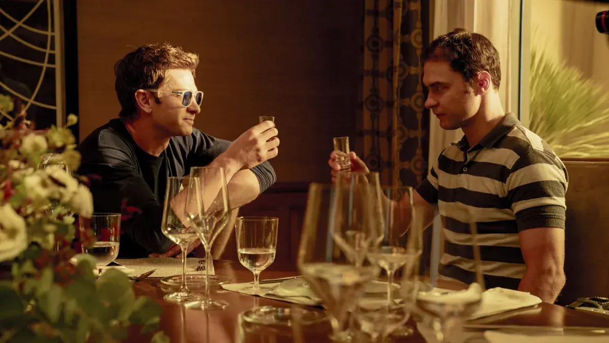 Deux convives trinquent lors d'un dîner dans Artificial de Luca Guadagnino