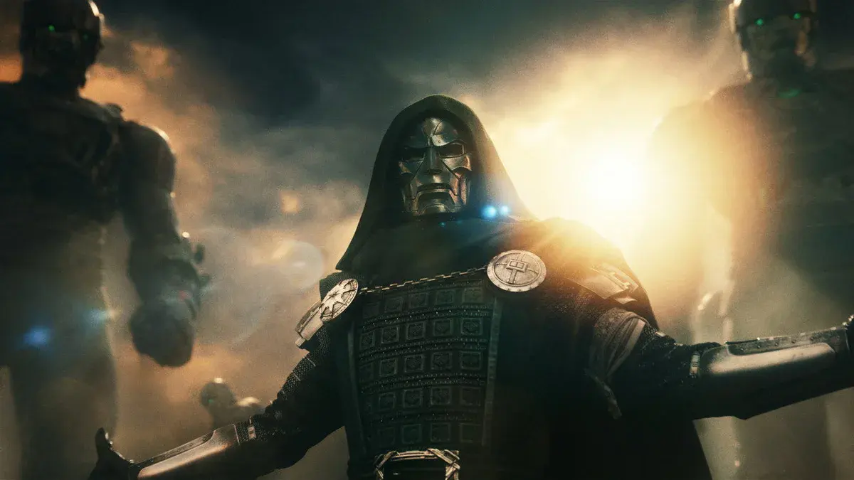 Docteur Fatalis, masque de métal et capuche, ouvre les bras entre deux robots dans Avengers : Doomsday
