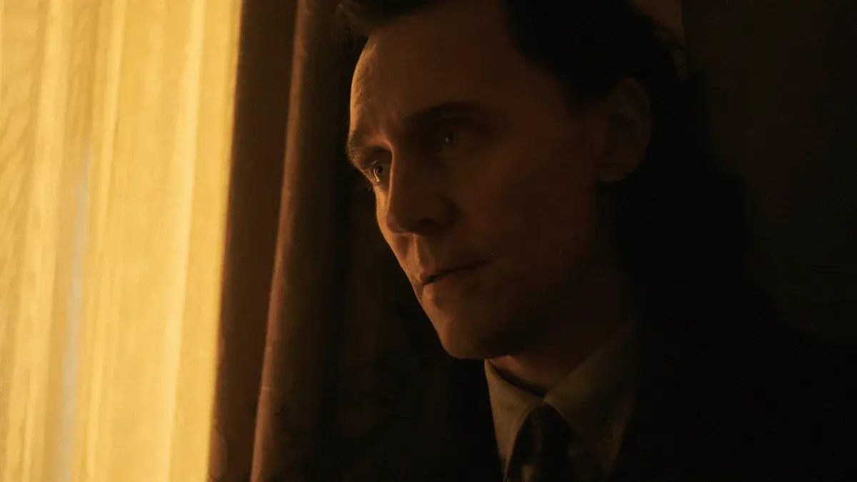 Loki, joué par Tom Hiddleston, le visage éclairé par une lumière dorée de fenêtre dans Avengers : Doomsday