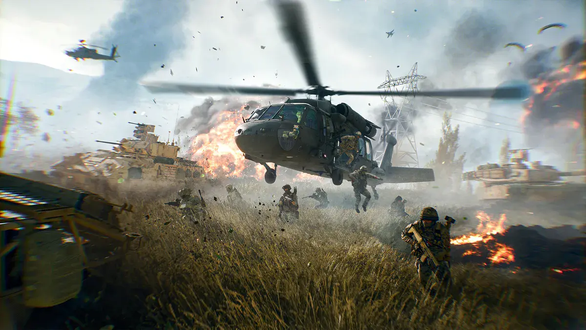 Un hélicoptère dépose une escouade au milieu des blindés et des explosions dans un champ en feu, visuel officiel de Battlefield 6