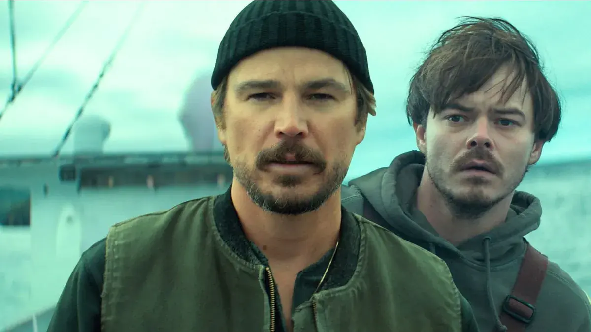 Josh Hartnett en bonnet noir et Charlie Heaton, l'air inquiet, sur le pont d'un bateau dans la série Below
