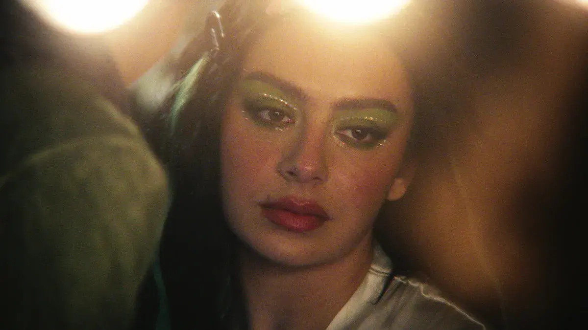 Charli XCX, maquillage vert et lumières de scène, dans le faux documentaire The Moment d'Aidan Zamiri