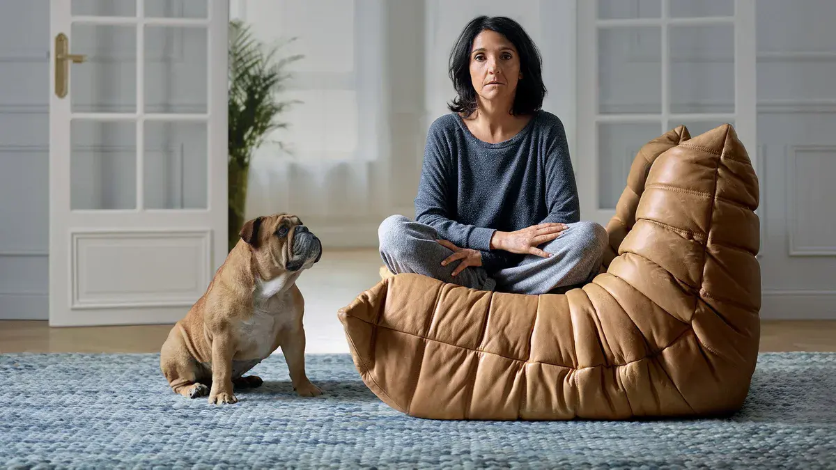 Désordres : Florence Foresti assise dans un fauteuil en cuir, à côté d'un bouledogue