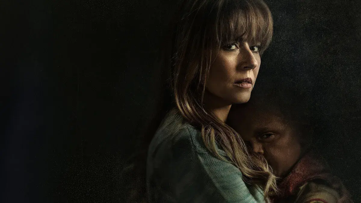 Linda Cardellini en Pamela Voorhees serrant contre elle le jeune Jason, sur un fond sombre, image promotionnelle de Crystal Lake