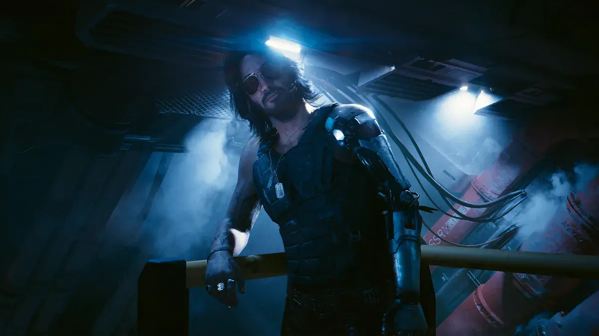 Cyberpunk 2077 Phantom Liberty : Johnny Silverhand, joué par Keanu Reeves, lunettes d'aviateur et bras cybernétique, sous un néon bleu