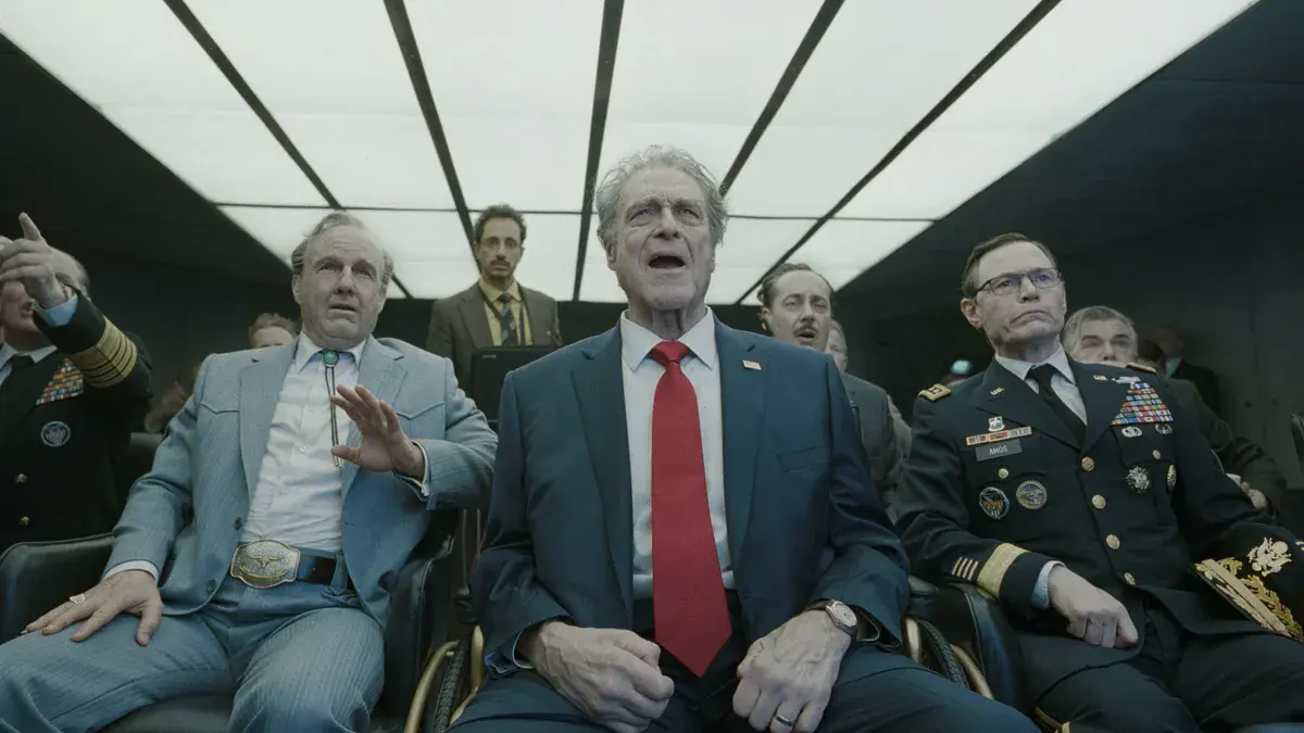 Tom Cruise en costume western et John Goodman en président des États-Unis, assis parmi des généraux dans une salle de crise, dans Digger d'Alejandro G. Iñárritu