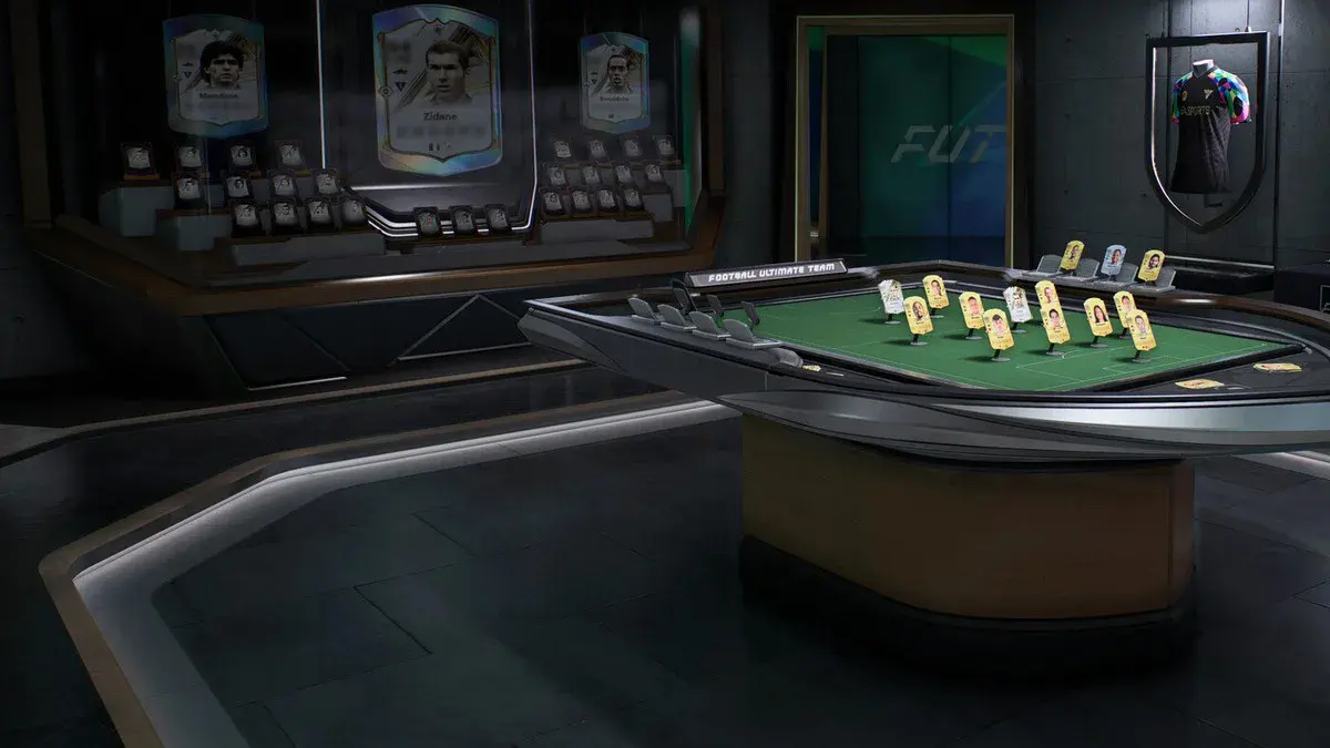 Salle du mode Ultimate Team dans EA Sports FC 27, avec les cartes de Zidane, Maradona et Ronaldinho et une table de composition d'équipe