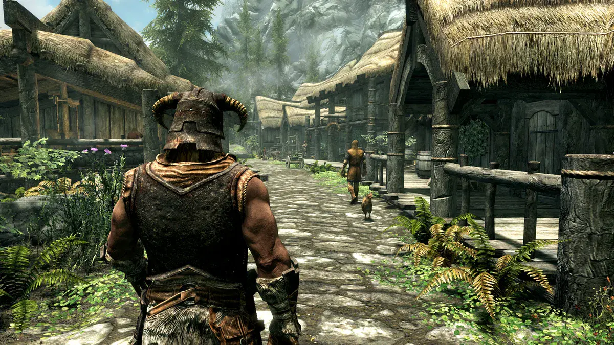 The Elder Scrolls V: Skyrim, l'Enfant de Dragon, casqué, marche dans les rues d'un village