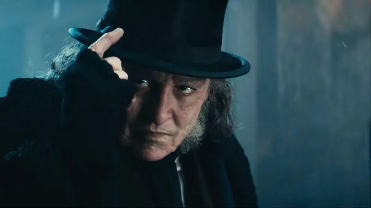 Johnny Depp en Ebenezer Scrooge, haut-de-forme et regard noir, dans le Scrooge de Ti West