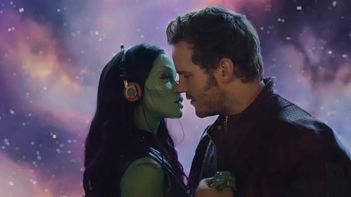 Peter Quill, joué par Chris Pratt, front contre front avec Gamora, jouée par Zoe Saldaña, devant un ciel étoilé dans Les Gardiens de la Galaxie