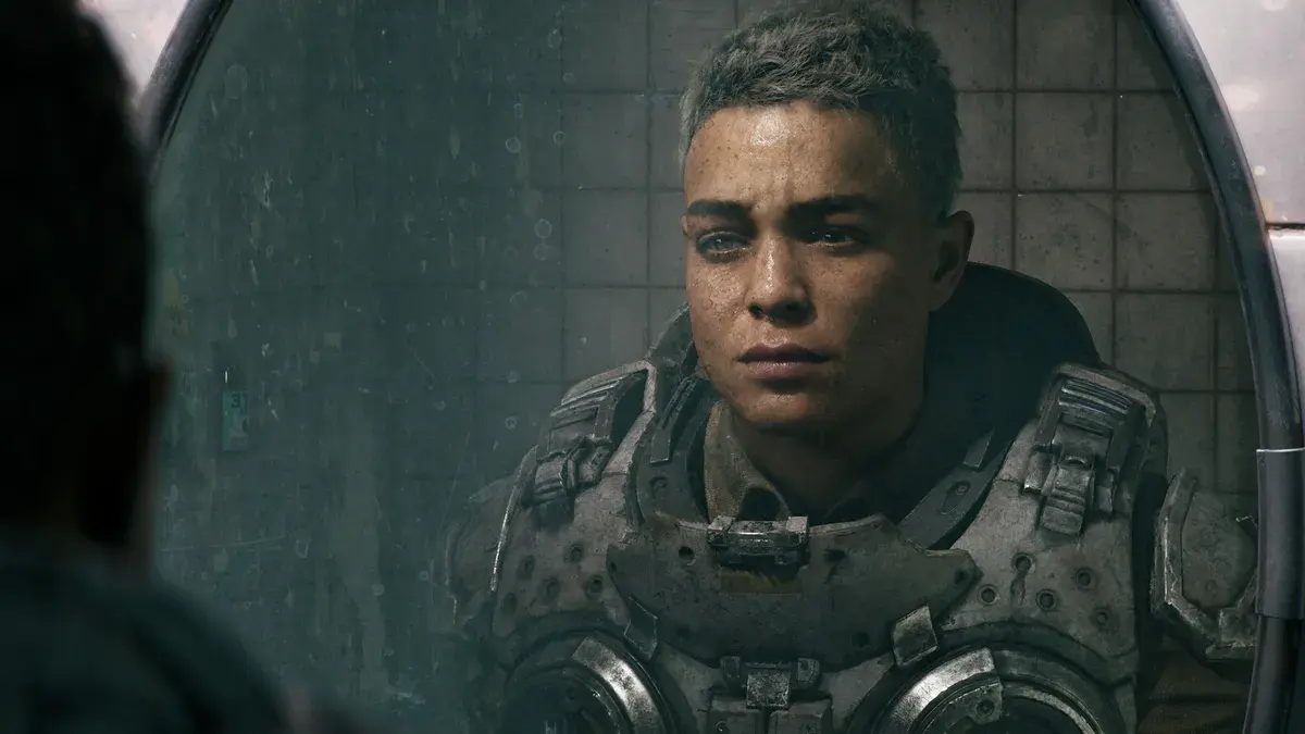 Un jeune soldat de la CGO en armure, le visage fatigué, se regarde dans le miroir d'une salle d'eau carrelée dans Gears of War: E-Day