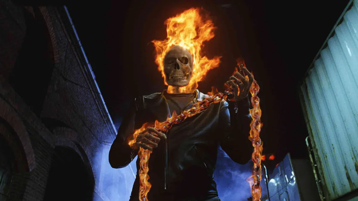 Ghost Rider, crâne en flammes et chaîne incandescente à la main, dans une ruelle de nuit dans Ghost Rider (2007) avec Nicolas Cage