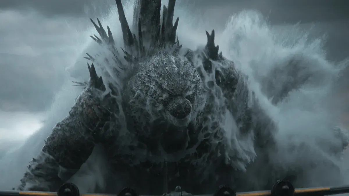 Godzilla Minus Zero : Godzilla surgit de la mer dans une gerbe d'écume, face à la proue d'un navire