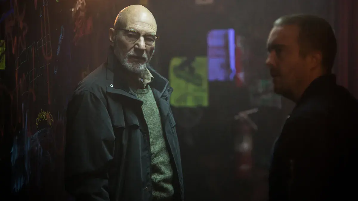 Patrick Stewart, lunettes et veste sombre, dans le rôle de Darcy, le patron du club néonazi de Green Room