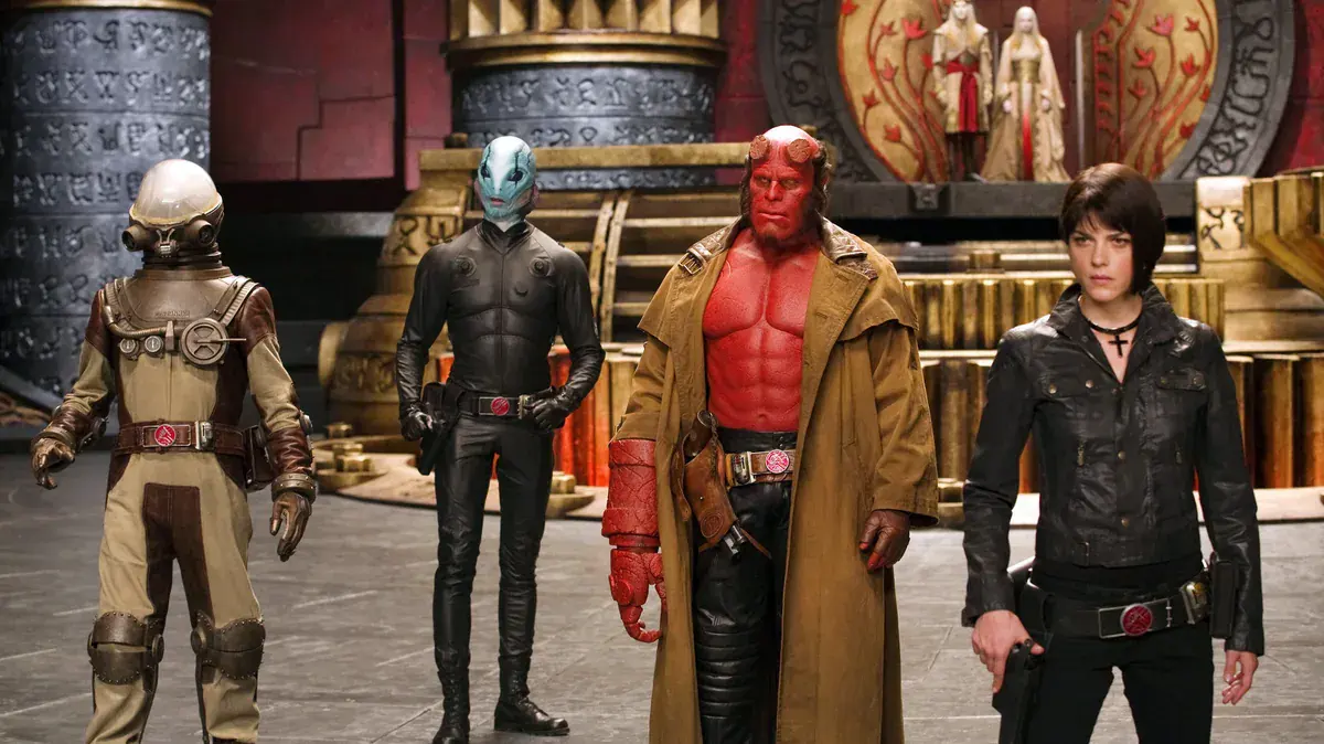 Ron Perlman en Hellboy aux côtés d'Abe Sapien, Johann Krauss et Liz Sherman dans Hellboy II : Les Légions d'or maudites