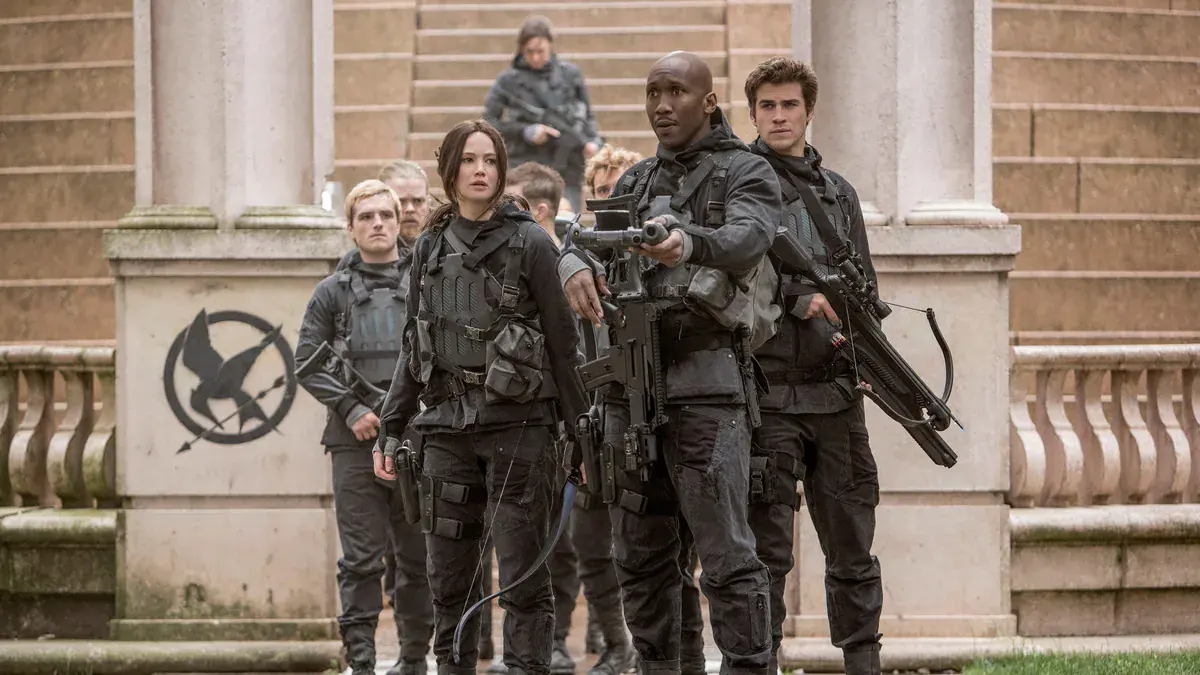 Jennifer Lawrence en Katniss Everdeen, entourée de Josh Hutcherson en Peeta, Mahershala Ali et Liam Hemsworth, dans Hunger Games : La Révolte, partie 2