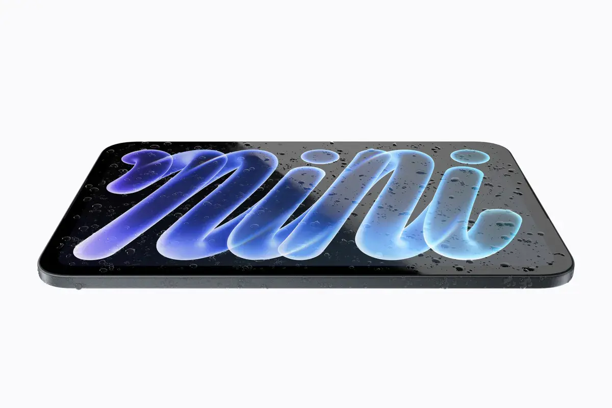Le nouvel iPad mini à écran OLED posé à plat, couvert de gouttes d'eau, sur un visuel officiel d'Apple