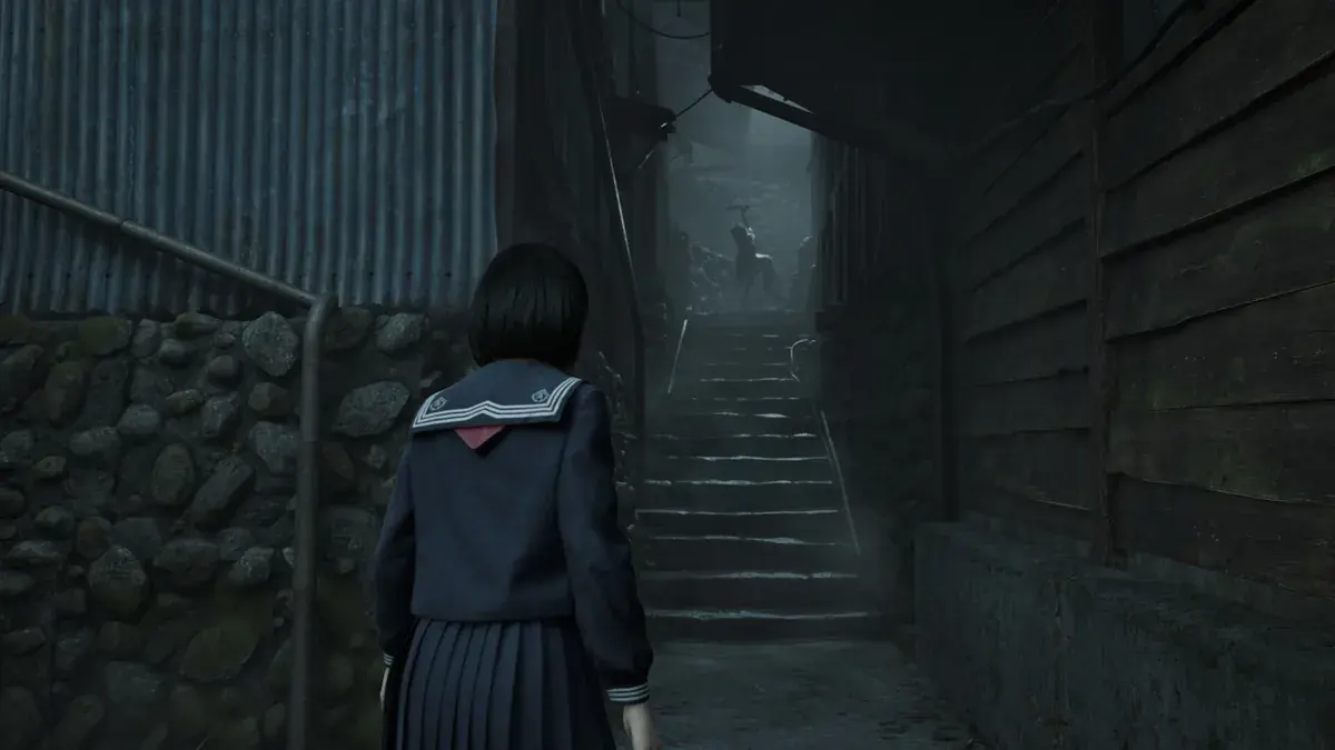Hinako, lycéenne en uniforme, avance dans une ruelle brumeuse vers un escalier dans Silent Hill f