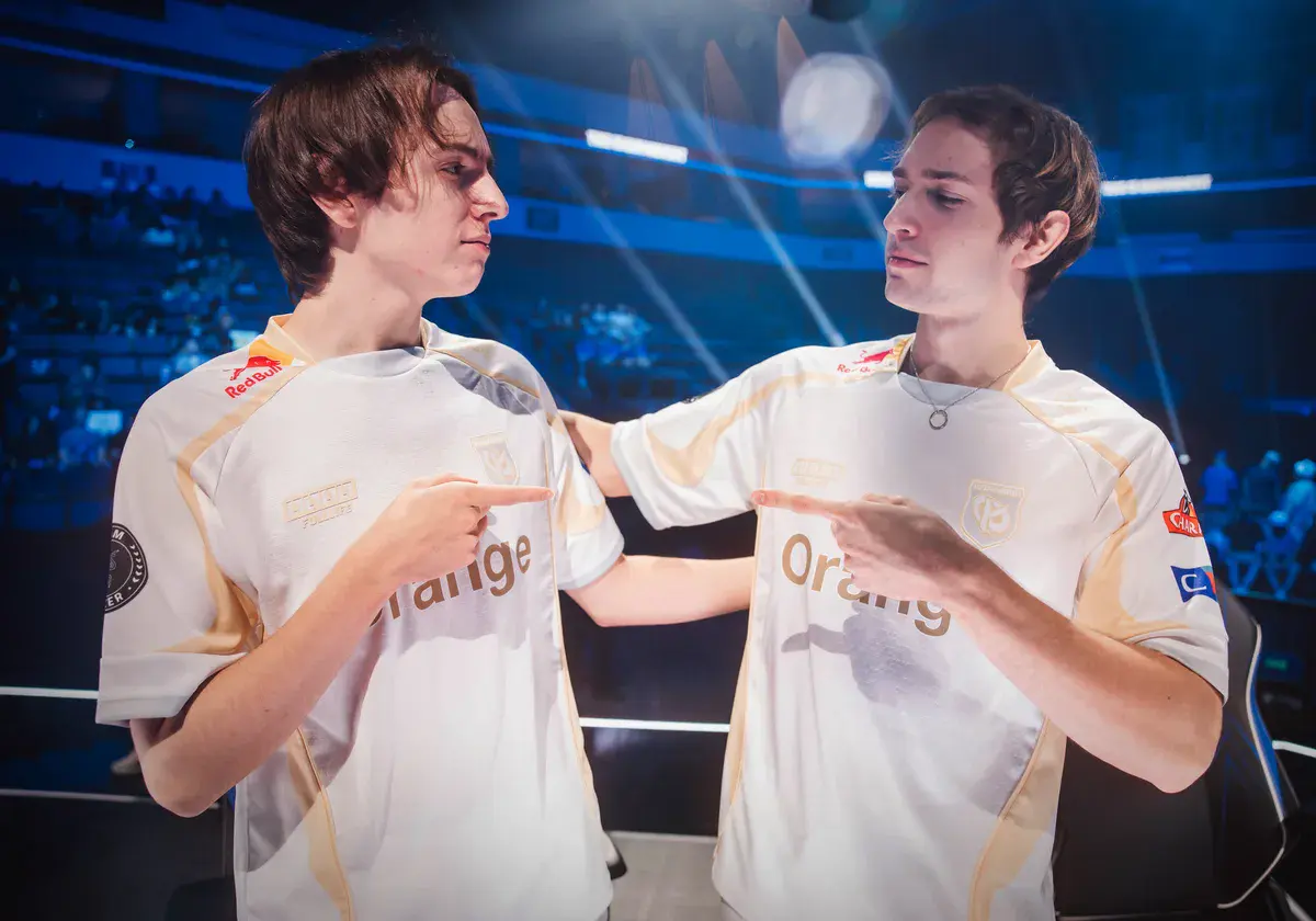 Caliste et Busio, tireur et support de la Karmine Corp, se désignent l'un l'autre en souriant sur la scène des Worlds 2026 après la victoire contre CTBC Flying Oyster