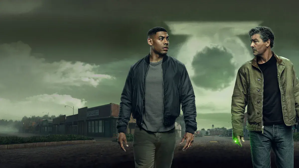 Aaron Pierre (John Stewart) et Kyle Chandler (Hal Jordan), l'anneau vert à la main, dans la rue d'une petite ville sous un ciel vert, visuel de la série Lanterns de HBO