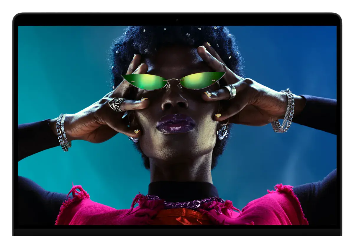 Le MacBook Pro 14 pouces M6 affiche le portrait d'une femme aux lunettes vertes sur son écran Liquid Retina XDR à encoche