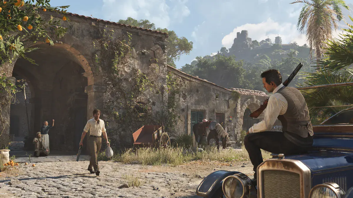 Enzo Favara traverse la cour d'une ferme sicilienne sous le regard d'un mafieux assis sur le capot d'une voiture ancienne, dans Mafia: The Old Country