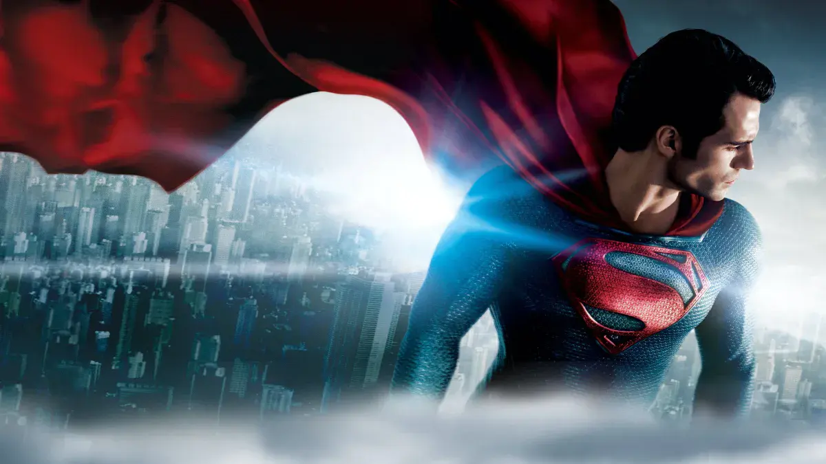 Henry Cavill en Superman, cape rouge au vent, au-dessus d'une ville dans Man of Steel de Zack Snyder