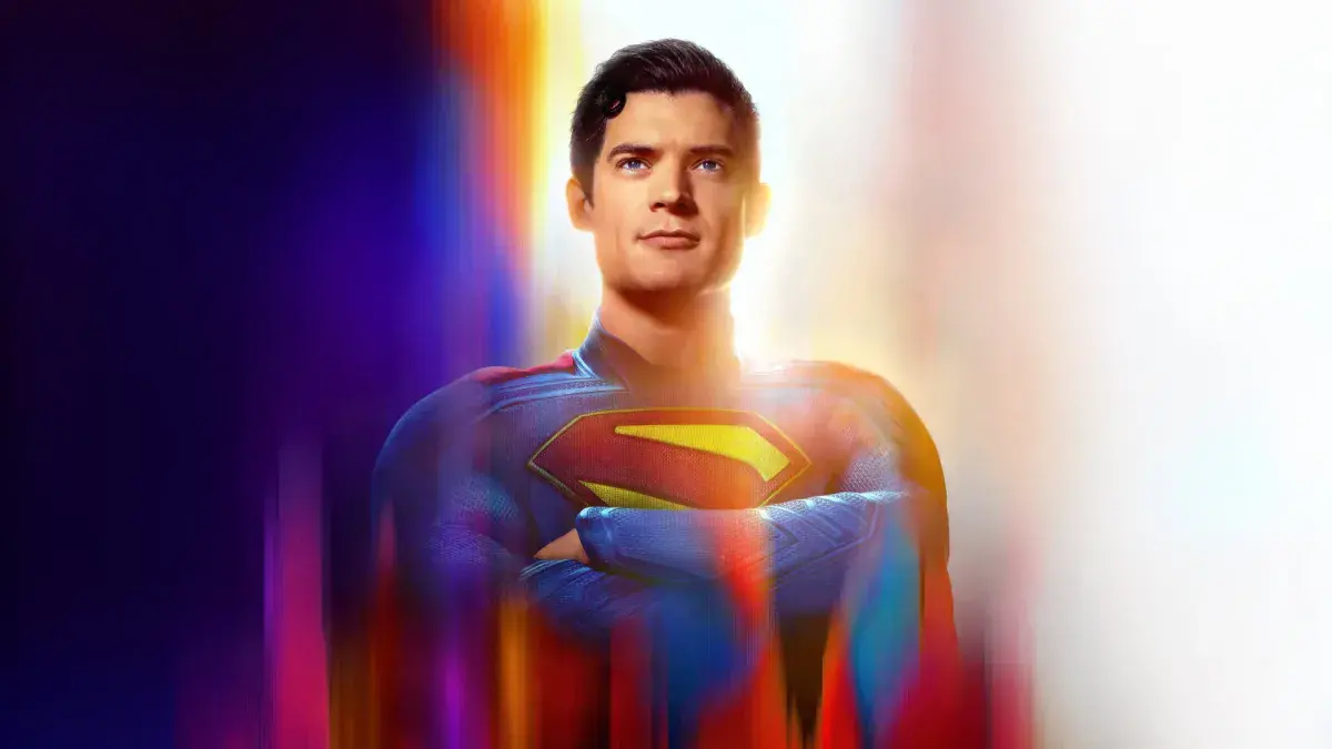 David Corenswet en costume de Superman, bras croisés, sur un visuel promotionnel du Superman de James Gunn
