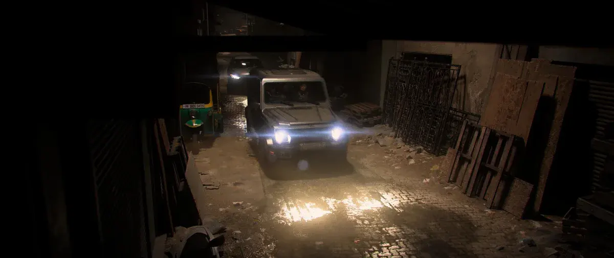 Un 4x4 aux phares allumés s'engage de nuit dans une ruelle pavée, un rickshaw garé sur le côté, dans Call of Duty: Modern Warfare 4