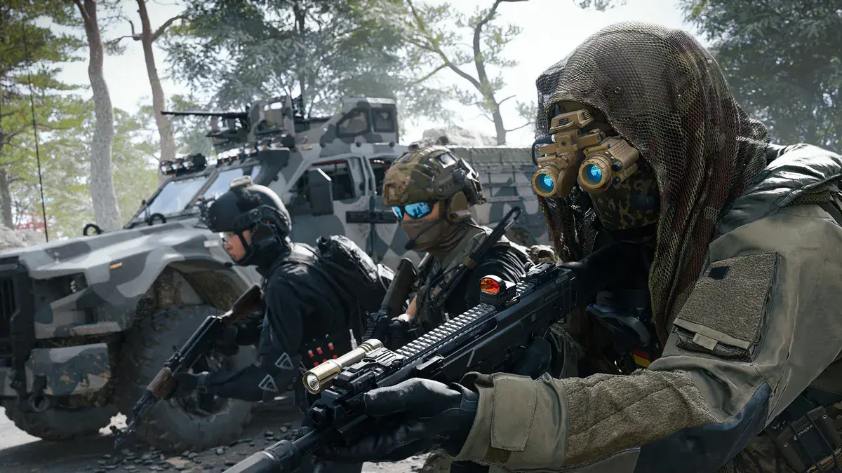 Trois opérateurs armés, dont un au visage couvert d'un filet de camouflage et de jumelles de vision nocturne, devant un blindé dans le mode DMZ de Modern Warfare 4