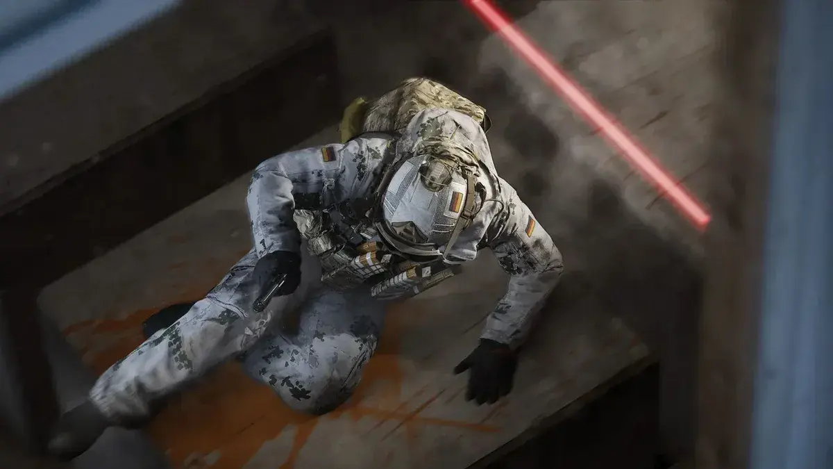 Un opérateur en tenue de camouflage hivernal se hisse sur une plateforme en bois, vu du dessus, dans Modern Warfare 4