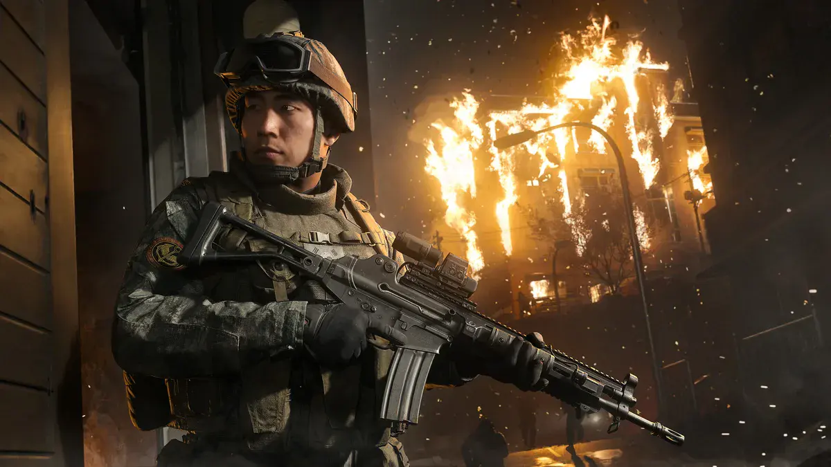 Un jeune soldat sud-coréen, casque sur la tête et fusil en main, devant un immeuble en flammes dans Call of Duty: Modern Warfare 4