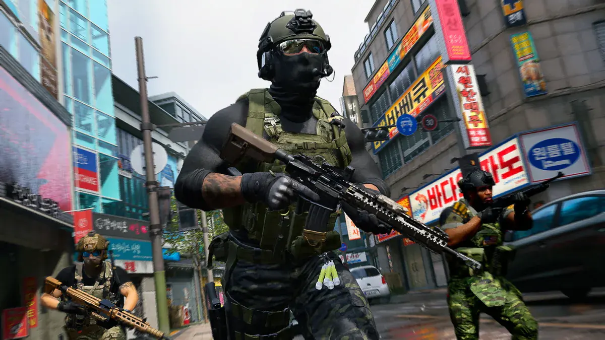 Opérateur masqué de Modern Warfare 4, fusil en main, dans une rue commerçante coréenne couverte d'enseignes, deux coéquipiers armés derrière lui