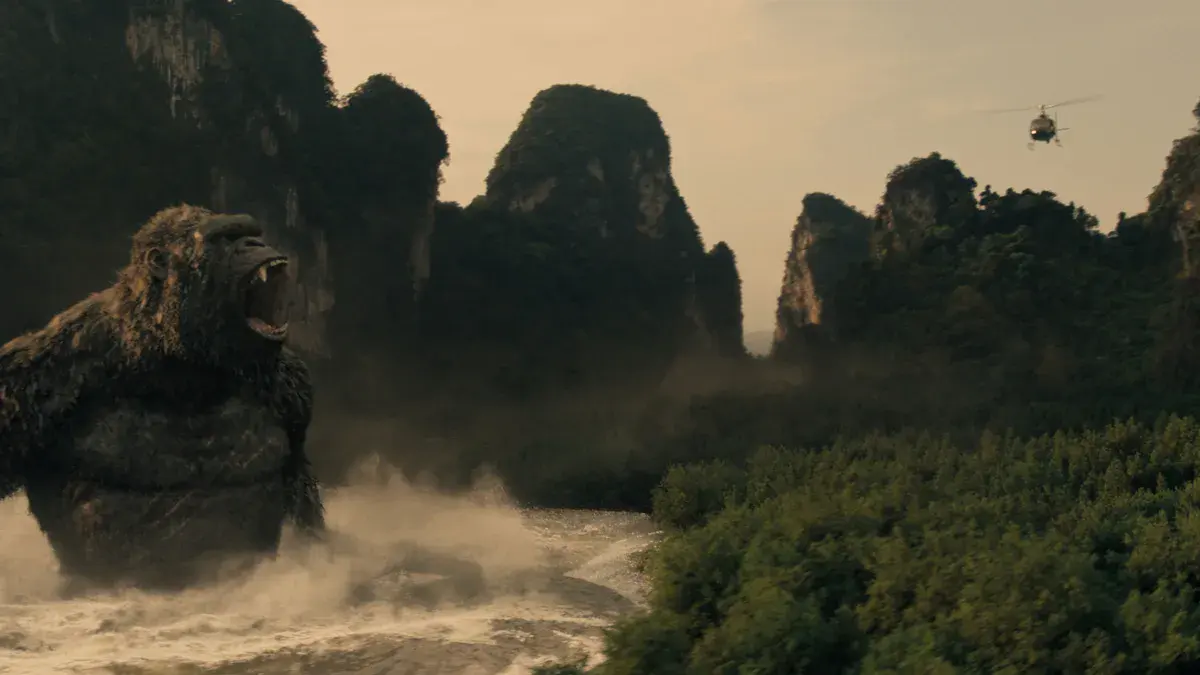 Kong rugit dans une rivière de Skull Island, un hélicoptère au-dessus des pitons rocheux, dans la saison 2 de Monarch: Legacy of Monsters