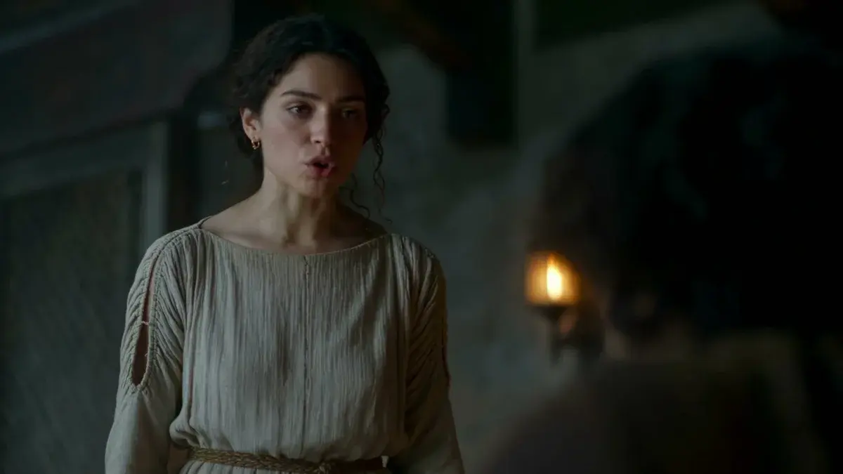 Image générée par IA (Grok Imagine) : une jeune femme en tunique de lin éclairée par une torche, dans le premier épisode de L'Odyssée de Wonder Studios