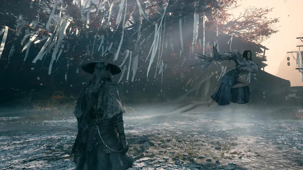 Phantom Blade Zero : Soul, vu de dos sous son chapeau de paille, fait face à une combattante en robe bleue qui s'élance sous un arbre couvert de rubans blancs