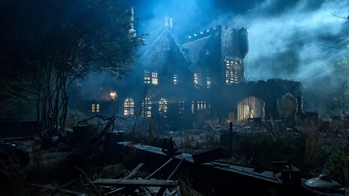 Le manoir de Hill House éclairé dans la brume nocturne, dans la série The Haunting of Hill House