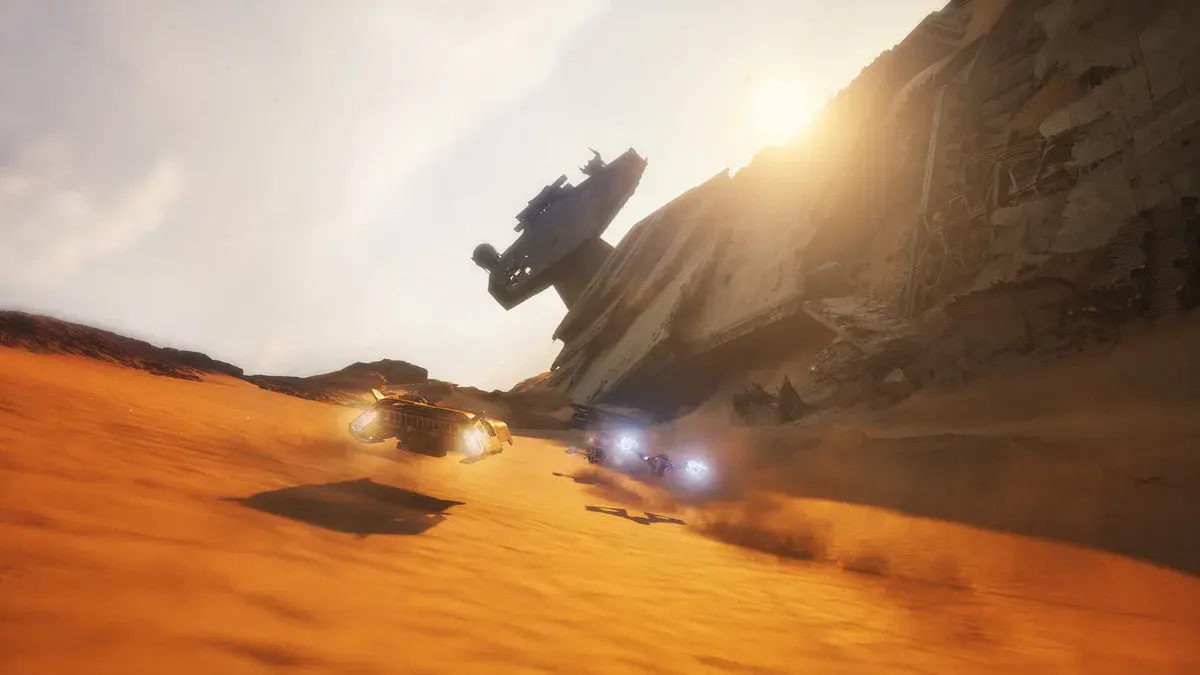 Deux véhicules à répulseurs filent sur les dunes au pied de l'épave d'un Destroyer stellaire, dans Star Wars: Galactic Racer