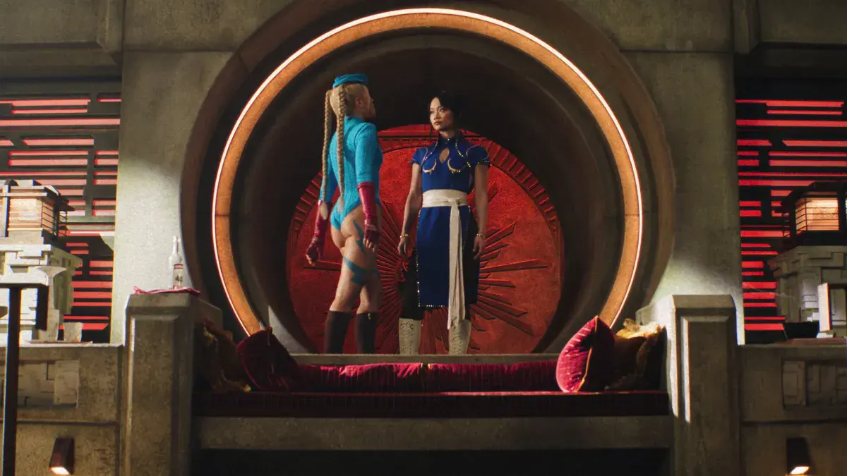 Cammy en justaucorps bleu et Chun-Li en robe bleue brodée, face à face devant un grand disque rouge dans le film Street Fighter de Kitao Sakurai