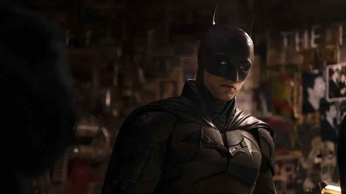 Robert Pattinson masqué en Batman, regard tourné vers un interlocuteur, dans The Batman de Matt Reeves (2022)