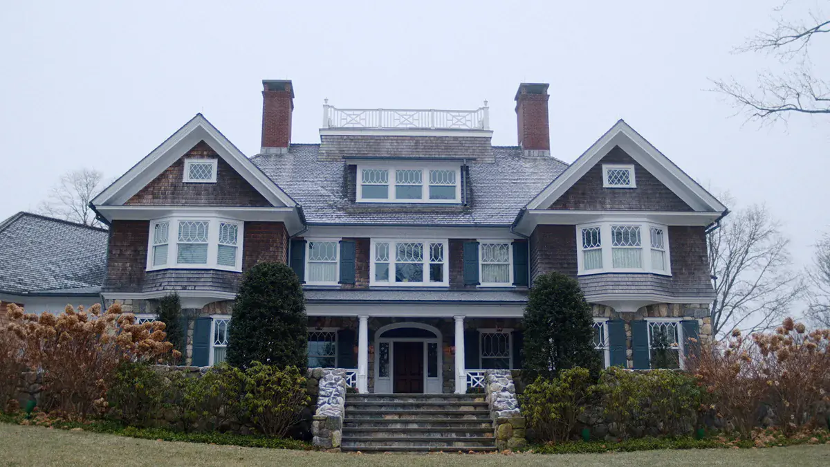 La façade de la maison des Brannock sous un ciel gris dans la série The Watcher de Netflix