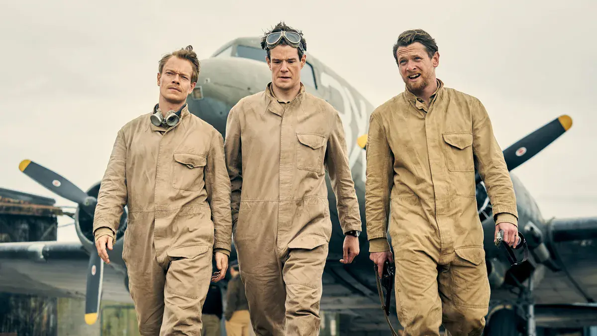 SAS Rogue Heroes : les trois officiers fondateurs du SAS en combinaison de saut devant un avion de transport