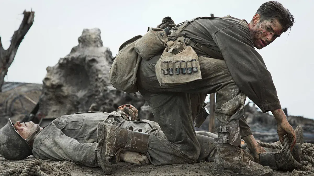 Tu ne tueras point : Andrew Garfield en infirmier militaire, une corde à la main, penché sur un soldat blessé au sommet de l'escarpement d'Okinawa