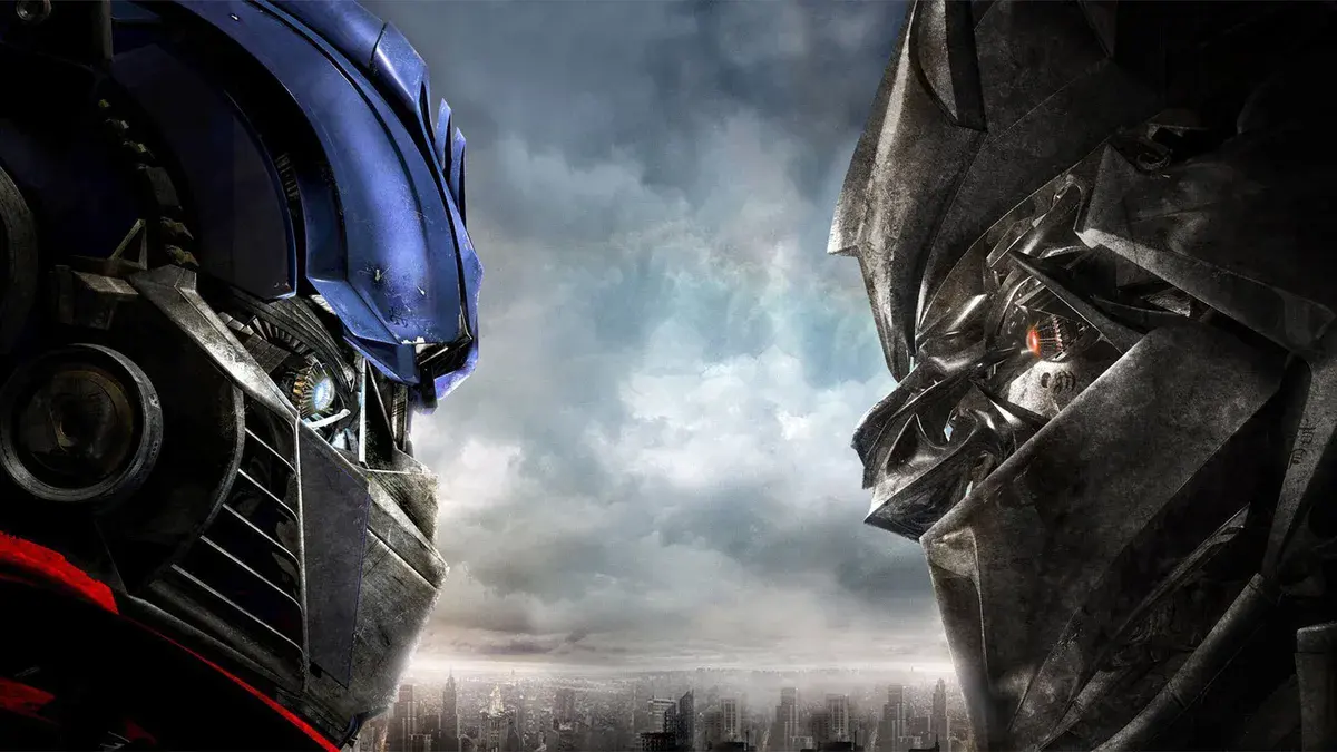 Les visages d'Optimus Prime et de Megatron face à face au-dessus d'une ville, dans Transformers de Michael Bay (2007)
