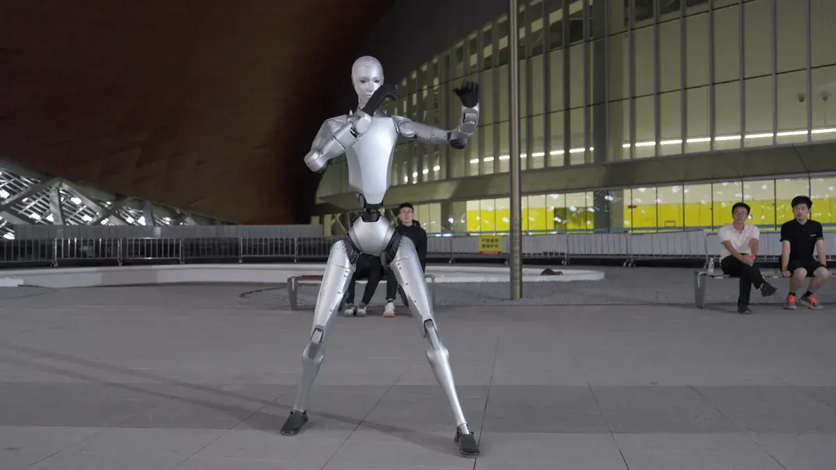 Le robot humanoïde Unitree H2 de série, argenté, en garde de kung-fu sur une esplanade de nuit, visuel officiel d'Unitree