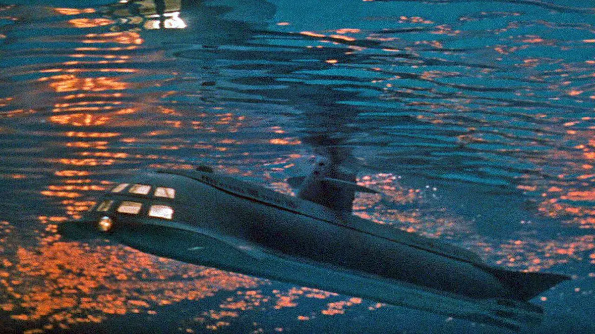 Le sous-marin Seaview, aux hublots éclairés, file sous la surface de l'océan au coucher du soleil dans Voyage au fond des mers, le film d'Irwin Allen de 1961