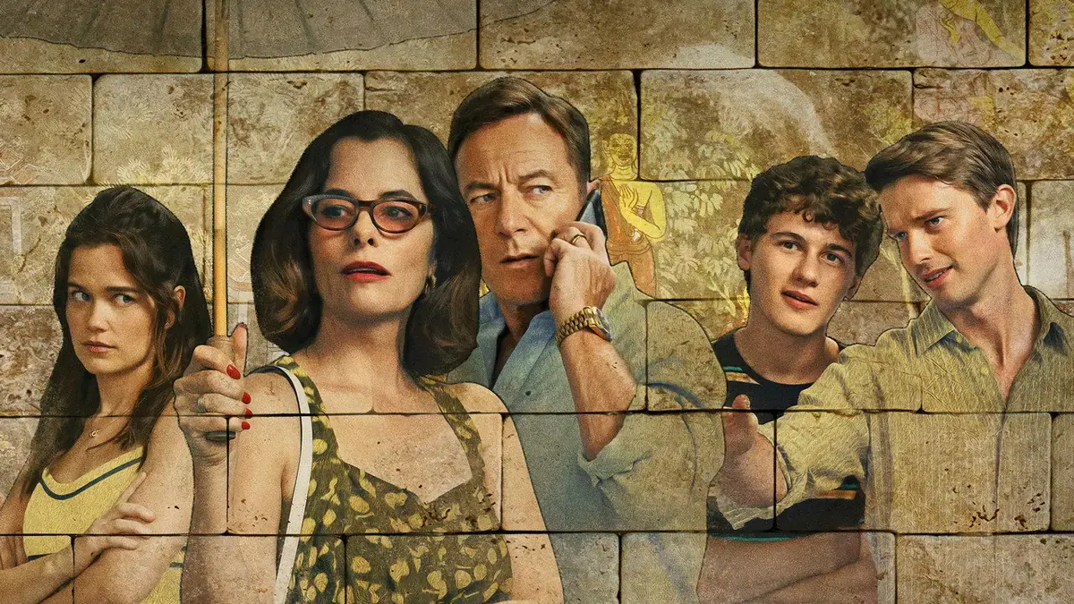 Sarah Catherine Hook, Parker Posey, Jason Isaacs au téléphone, Sam Nivola et Patrick Schwarzenegger, la famille Ratliff de la saison 3 de The White Lotus, devant un mur de pierre peint