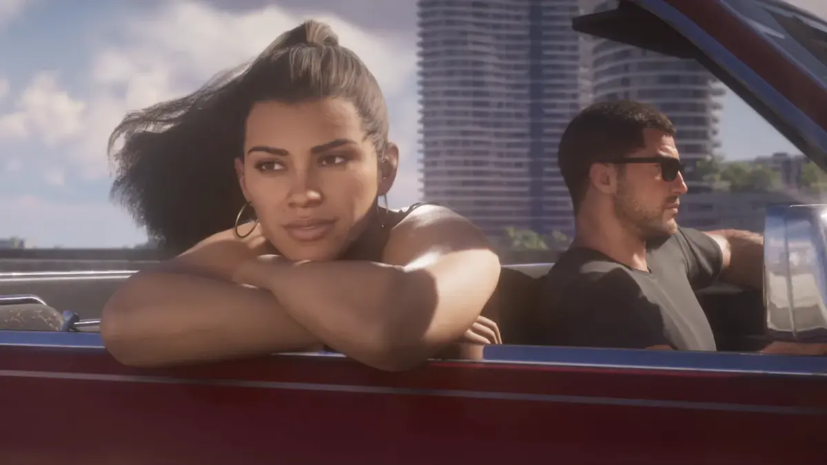 GTA 6 : Lucia en queue de cheval accoudée à la portière d'un cabriolet rouge, Jason en lunettes de soleil au volant, dans la bande-annonce de lancement